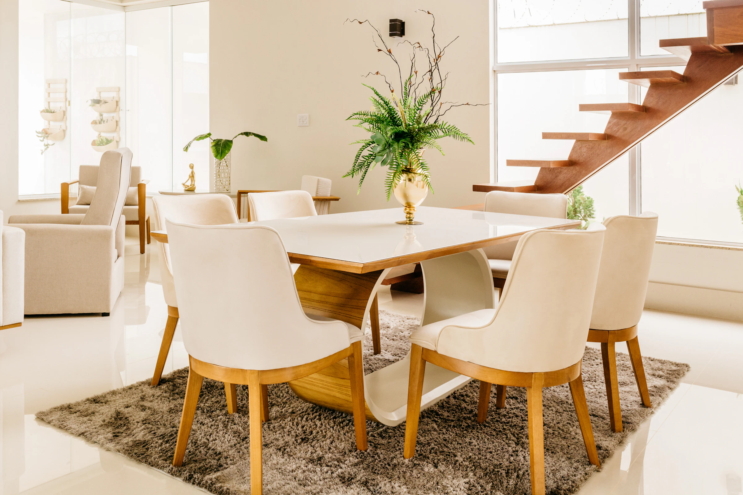 Oval white dining table with oak and cream upholstered chairs around it
