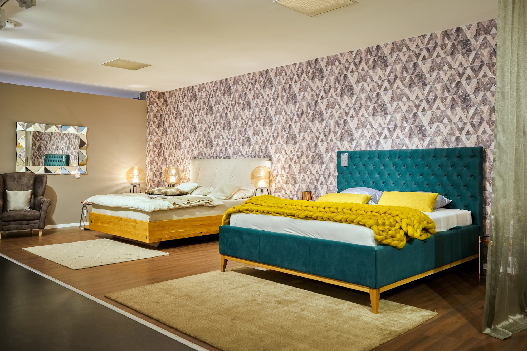 Showroom with two made-up beds, one with a yellow throw